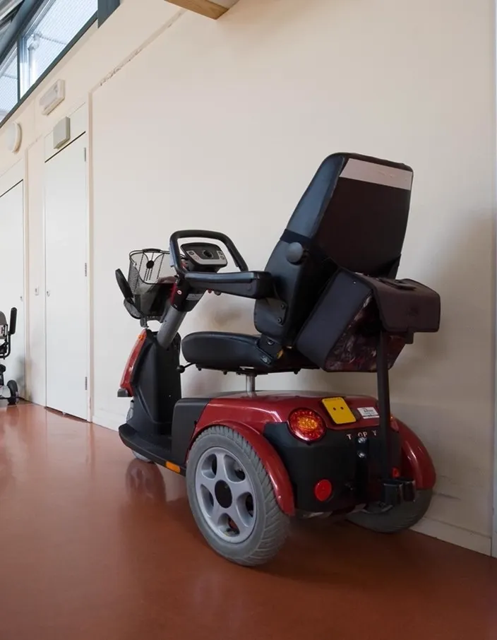 Scootmobiel geparkeerd in een gemeenschappelijke ruimte
